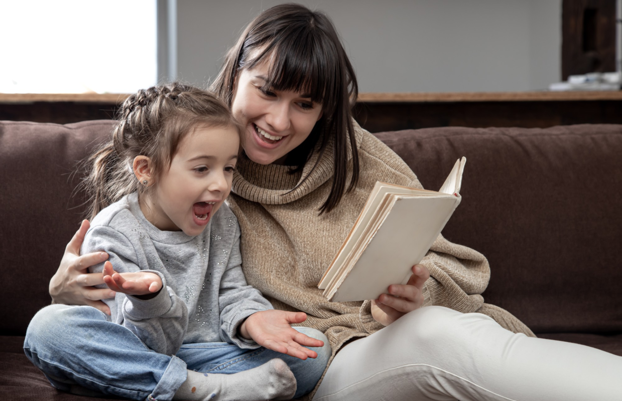 Mom and daughter spend time together reading a book.
